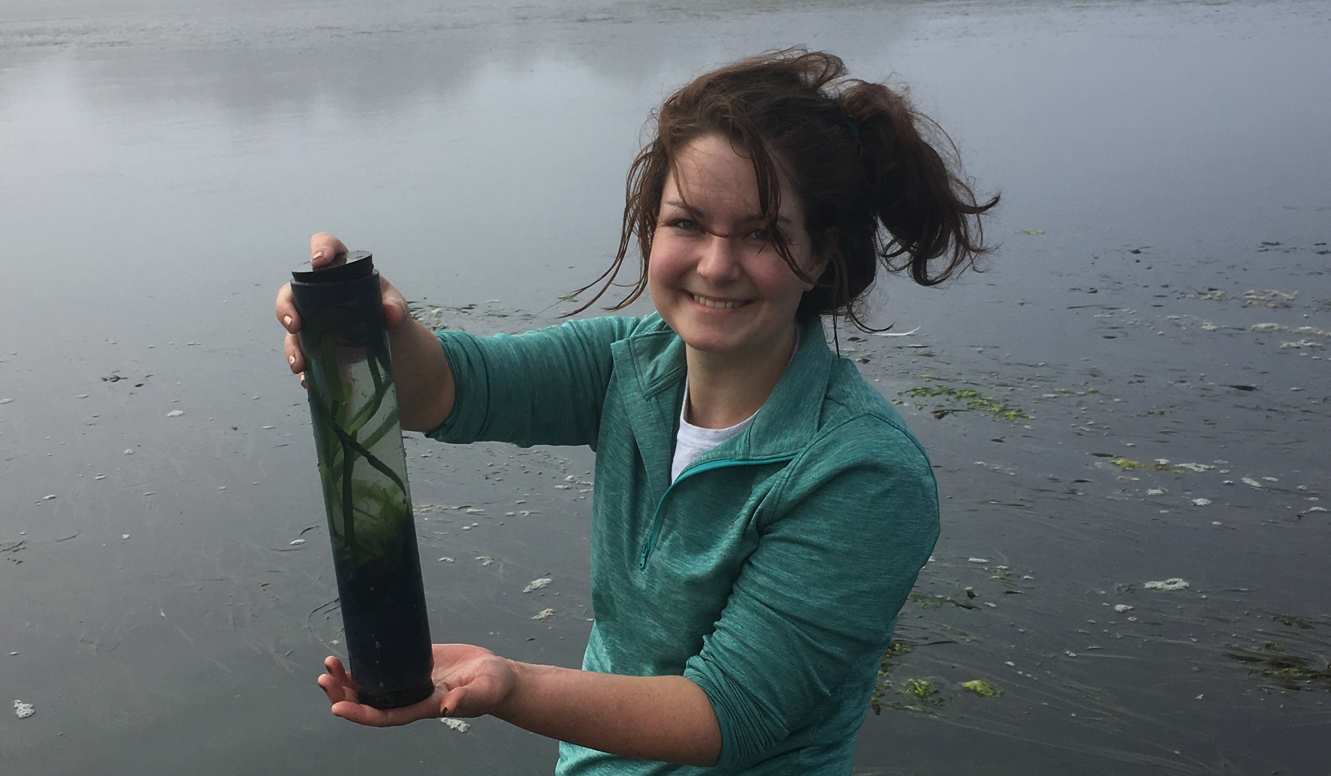 Photo of Cassie holding a core containing seagrass; Photo credit: Katy Dynarski